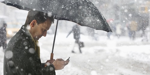 Man checking phone while in the snow